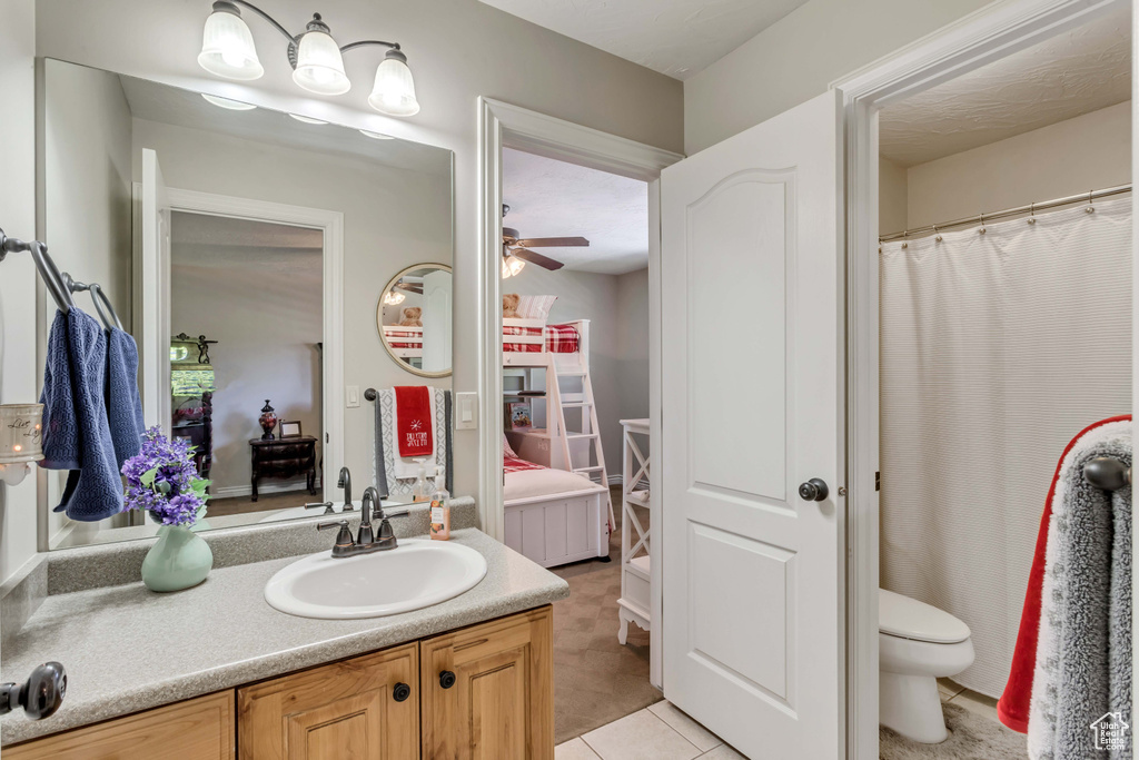 Bathroom featuring ceiling fan, toilet, tile floors, and vanity