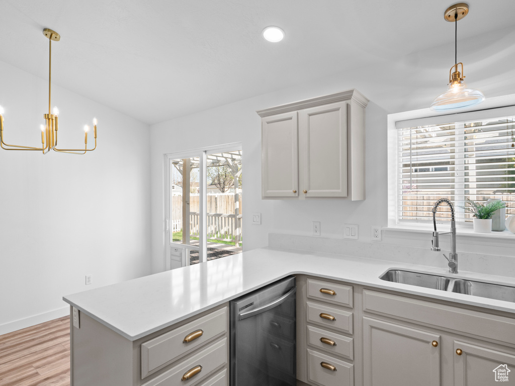 Kitchen with kitchen peninsula, gray cabinetry, dishwasher, sink, and pendant lighting