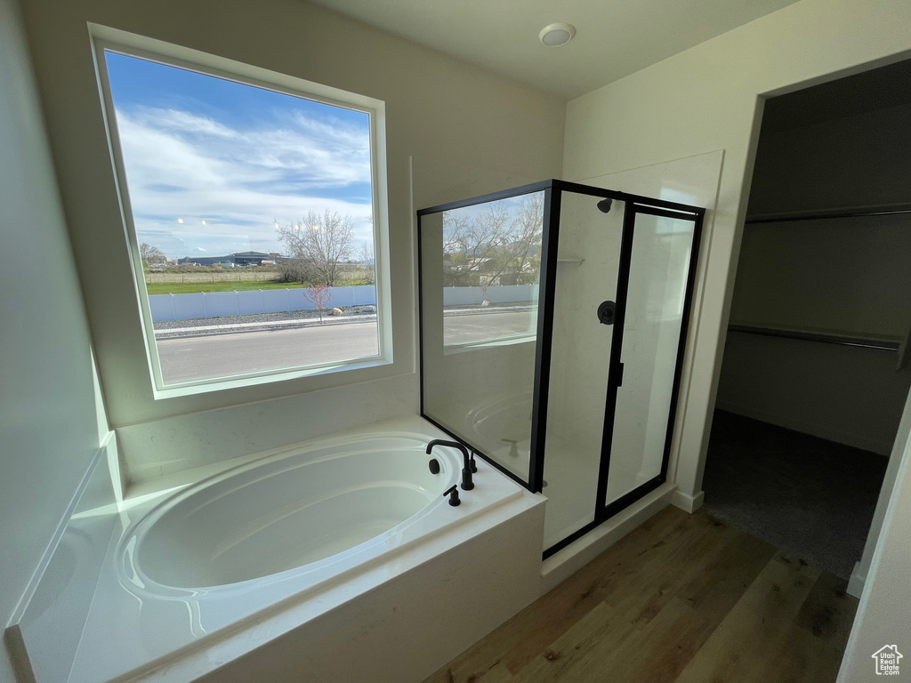Bathroom with wood-type flooring and separate shower and tub