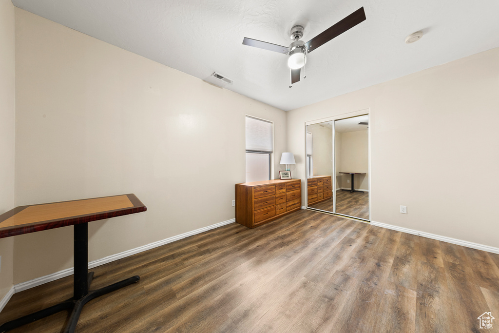 Unfurnished bedroom featuring a closet, hardwood / wood-style floors, and ceiling fan