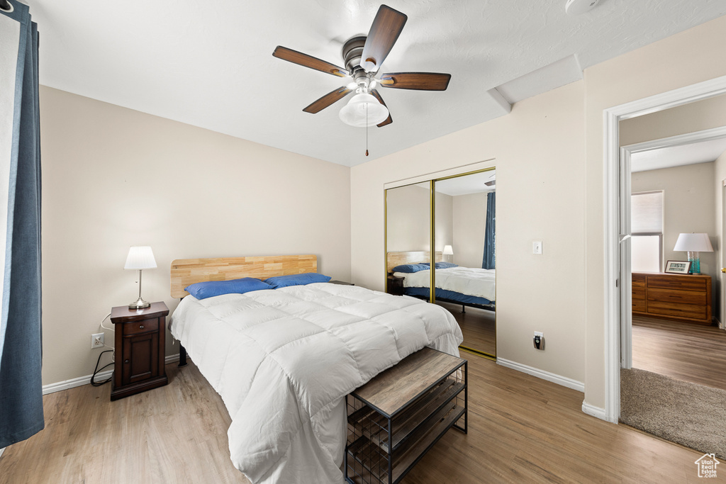 Bedroom with ceiling fan, a closet, and hardwood / wood-style floors