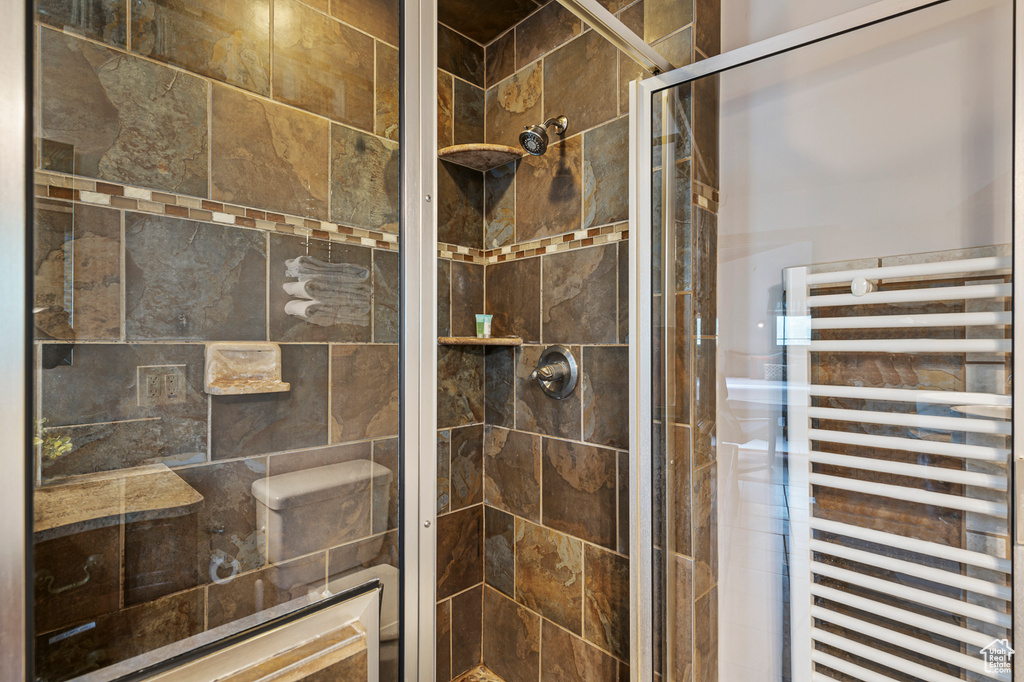 Bathroom featuring a shower with shower door and radiator