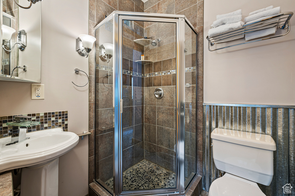Bathroom featuring toilet and a shower with shower door