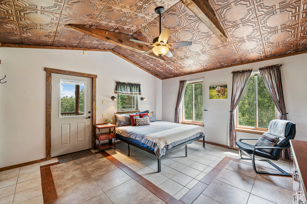 Tiled bedroom featuring vaulted ceiling and ceiling fan
