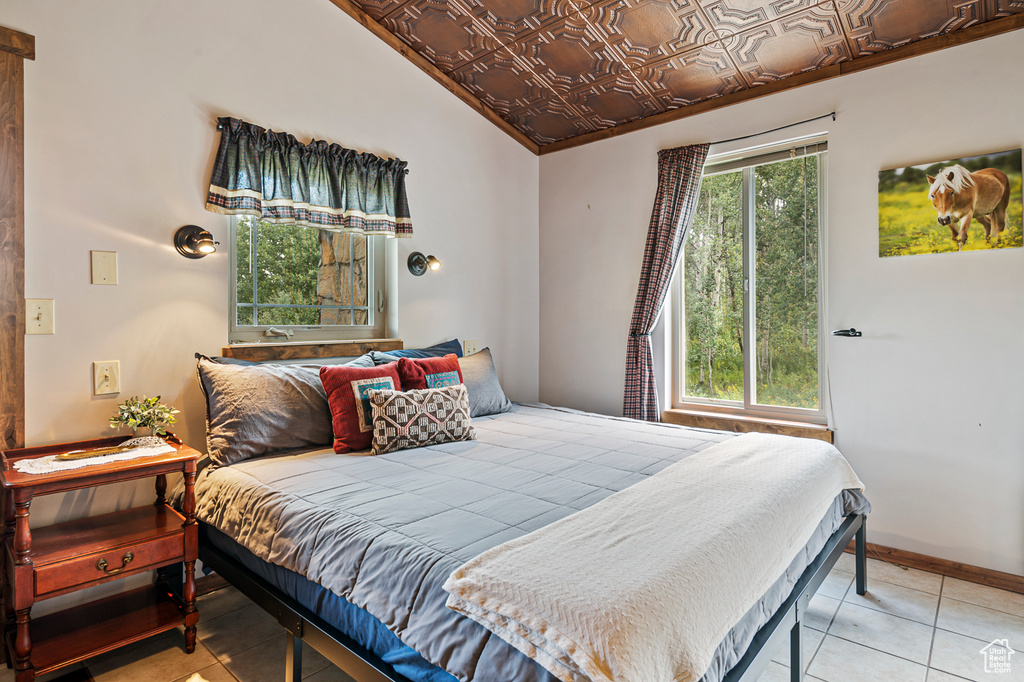 Tiled bedroom featuring vaulted ceiling