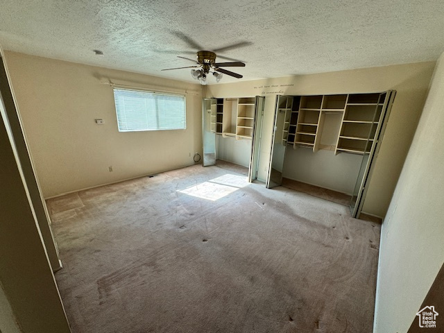 Unfurnished bedroom featuring ceiling fan, carpet flooring, and a textured ceiling