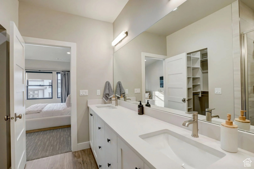 Bathroom featuring wood-type flooring and dual bowl vanity
