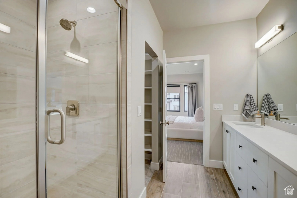 Bathroom with walk in shower, wood-type flooring, and oversized vanity