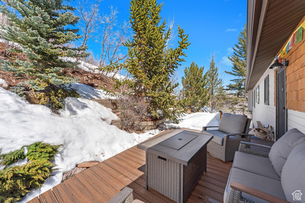 Snow covered deck featuring outdoor lounge area