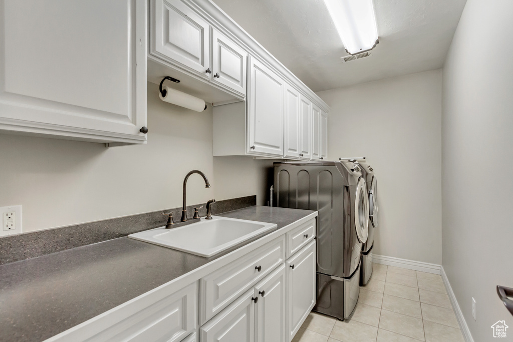 Laundry room featuring cabinets, sink, independent washer and dryer, and light tile flooring