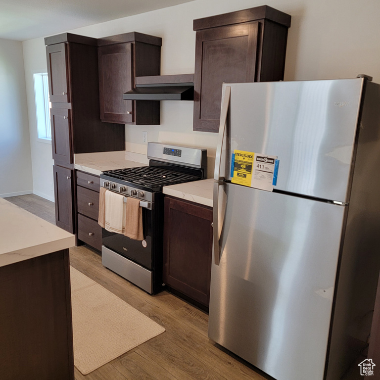 Kitchen featuring appliances with stainless steel finishes, light hardwood / wood-style floors, and dark brown cabinetry