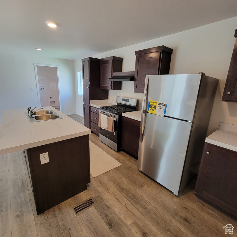 Kitchen featuring appliances with stainless steel finishes, light hardwood / wood-style flooring, and sink