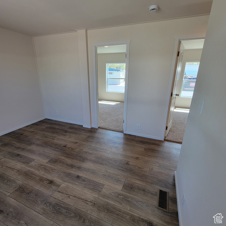 Unfurnished room with plenty of natural light and dark wood-type flooring