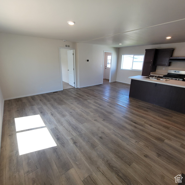 Unfurnished living room featuring dark hardwood / wood-style flooring and sink