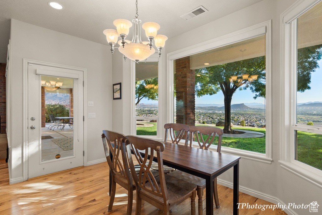 Dining area featuring light hardwood / wood-style flooring, a mountain view, and plenty of natural light