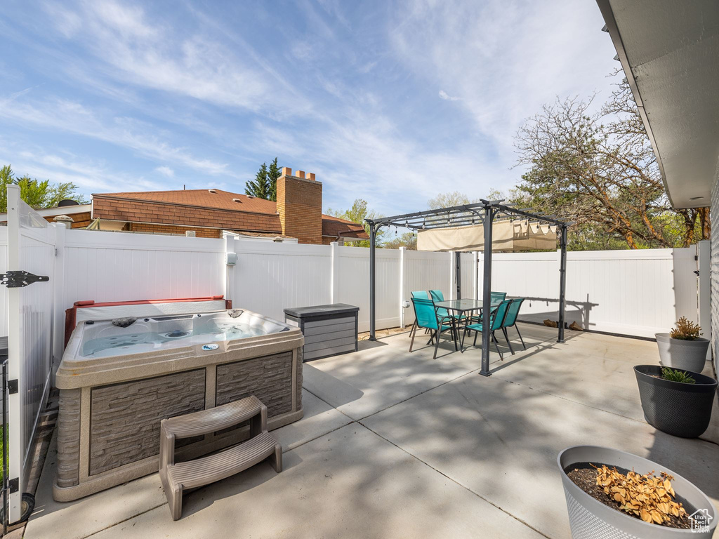 View of patio / terrace featuring a hot tub and a pergola