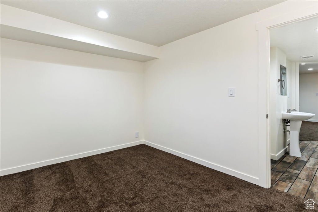 Unfurnished room with dark carpet and sink