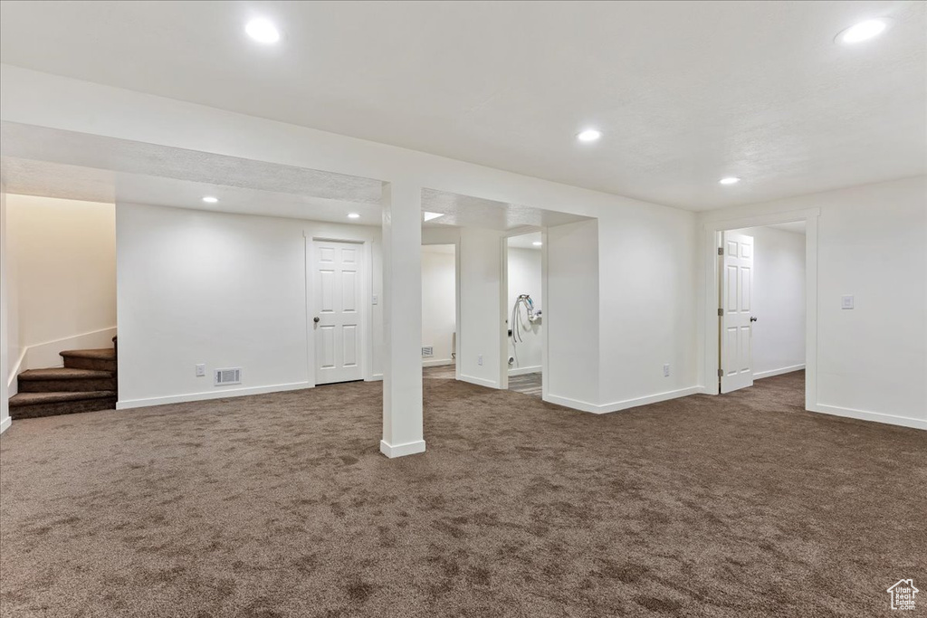 Basement with dark colored carpet