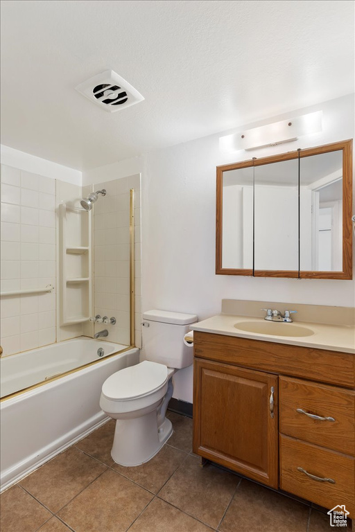 Full bathroom featuring tiled shower / bath combo, oversized vanity, toilet, and tile flooring