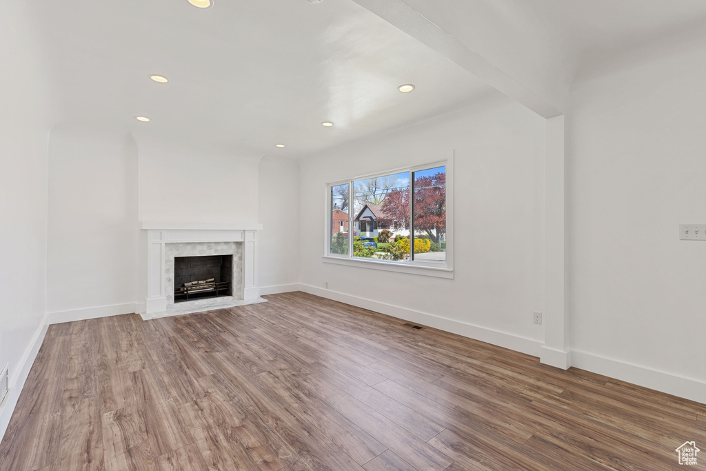 Unfurnished living room with hardwood / wood-style flooring and a fireplace