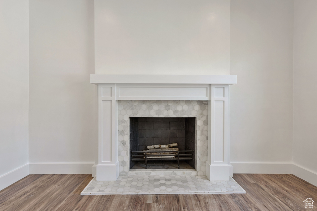 Room details featuring hardwood / wood-style flooring and a tile fireplace