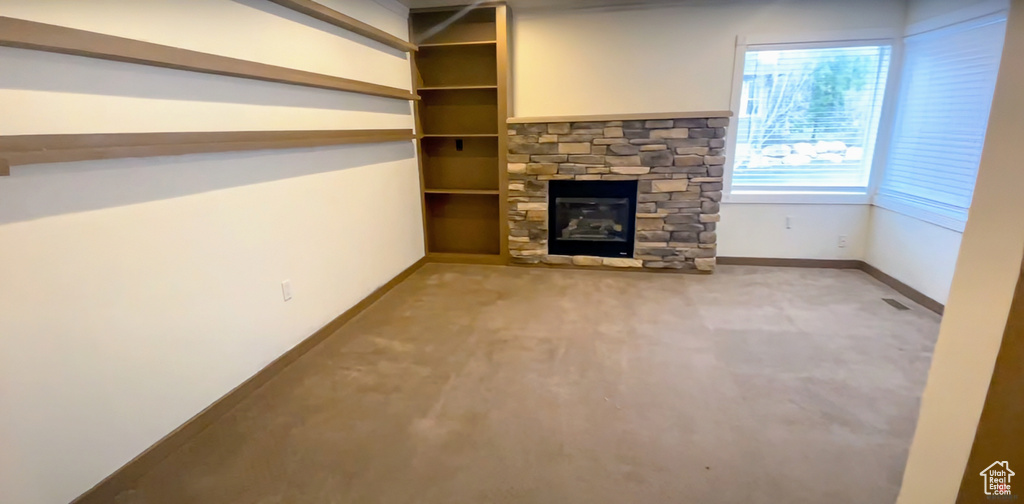 Unfurnished living room featuring a fireplace and carpet flooring