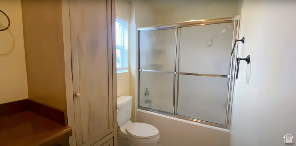 Bathroom featuring toilet and enclosed tub / shower combo