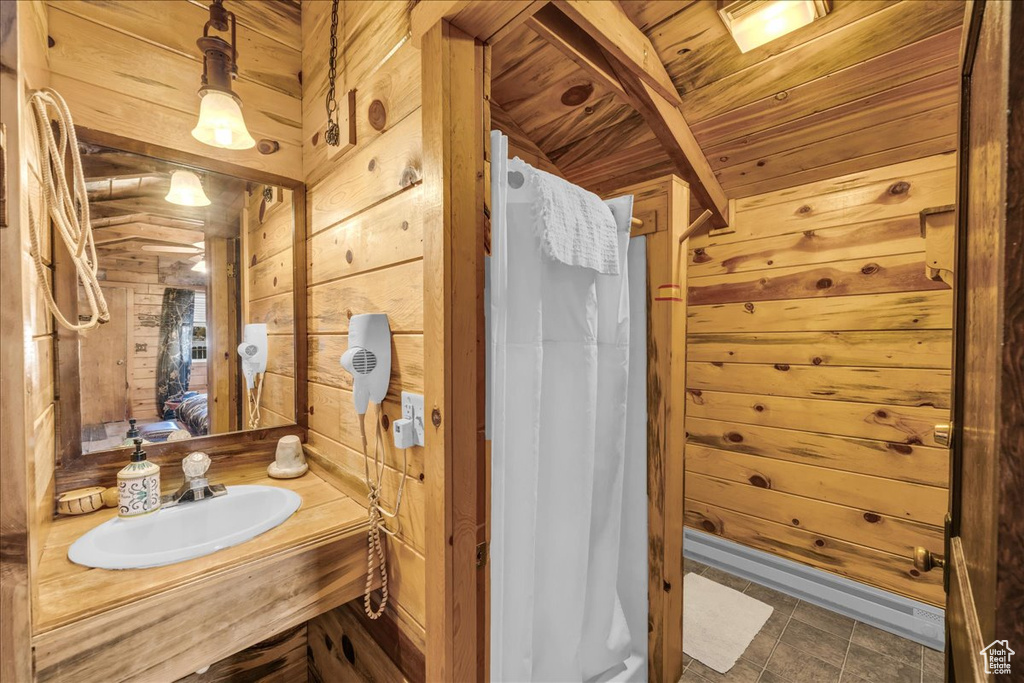 Bathroom featuring wood ceiling, wood walls, tile floors, and oversized vanity