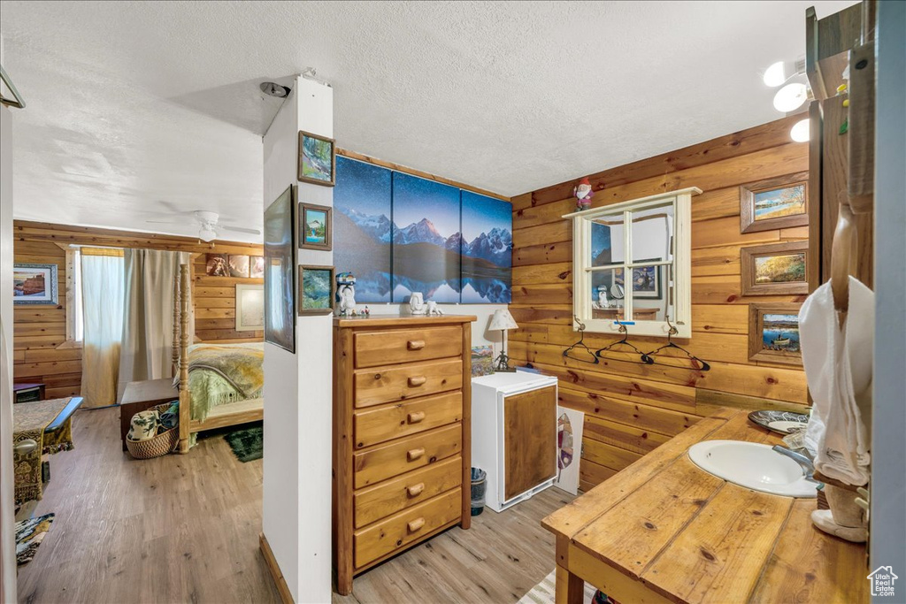 Interior space featuring a textured ceiling, hardwood / wood-style floors, vanity, and log walls