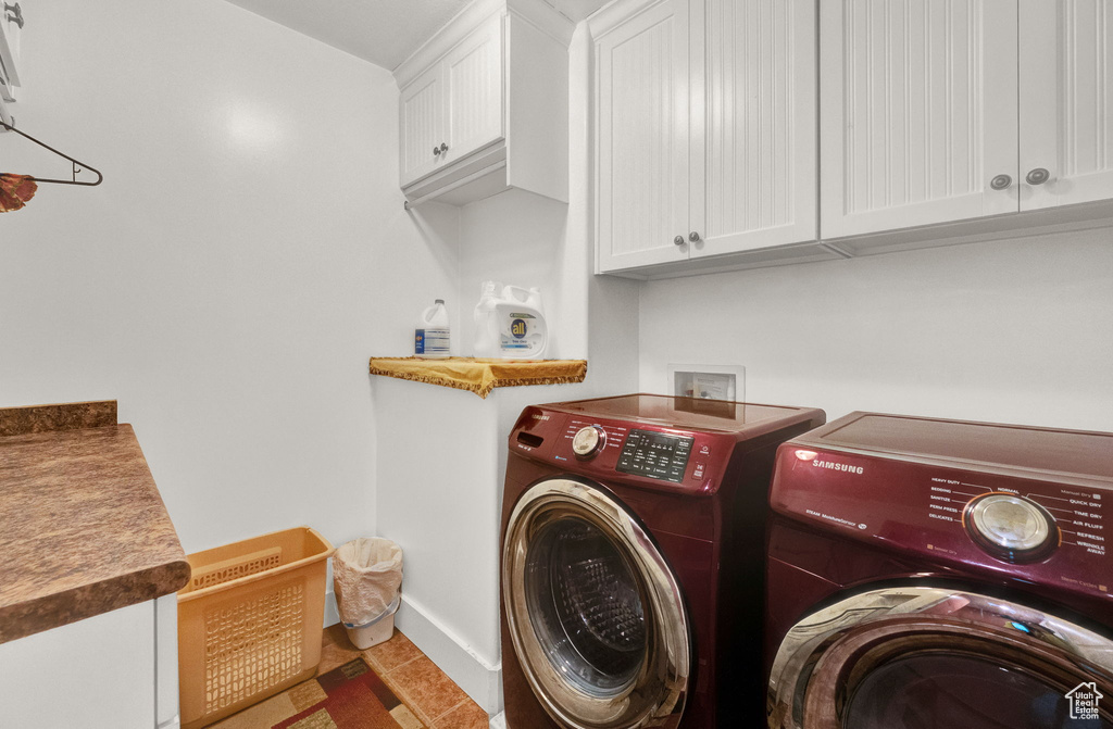 Laundry room featuring cabinets, washing machine and dryer, washer hookup, and tile flooring
