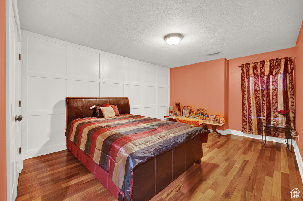 Bedroom featuring a textured ceiling and hardwood / wood-style floors