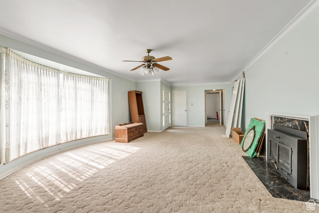 Interior space featuring ceiling fan, carpet, and crown molding