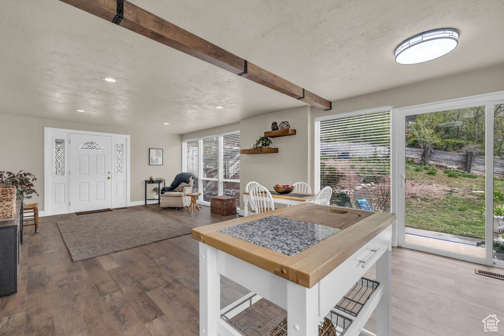 Kitchen with beamed ceiling, hardwood / wood-style flooring, and a healthy amount of sunlight