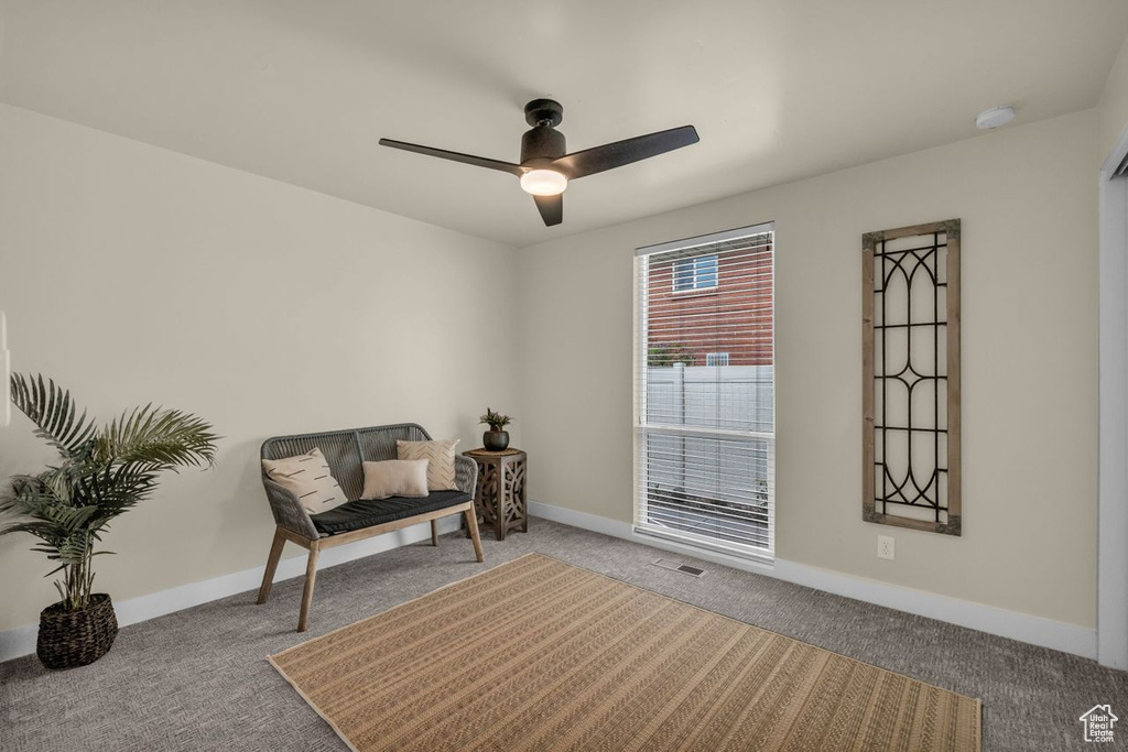 Living area featuring carpet floors and ceiling fan
