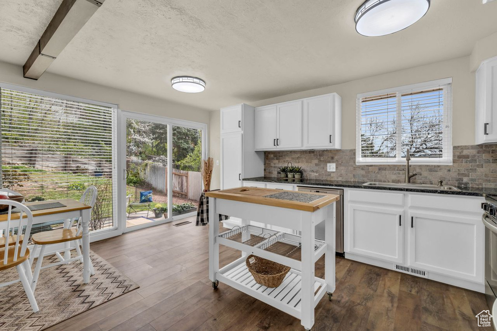 Kitchen with white cabinets, dark hardwood / wood-style floors, sink, and dishwasher