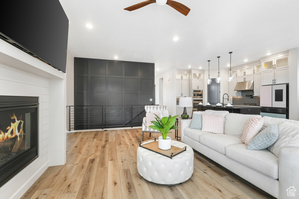 Living room featuring light hardwood / wood-style flooring, sink, and ceiling fan