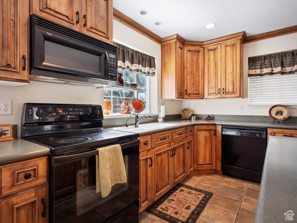 Kitchen with tile floors, ornamental molding, sink, and black appliances