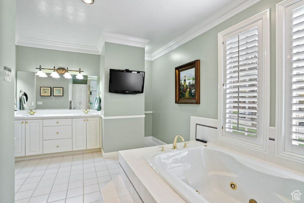Bathroom with oversized vanity, crown molding, tile flooring, double sink, and tiled bath