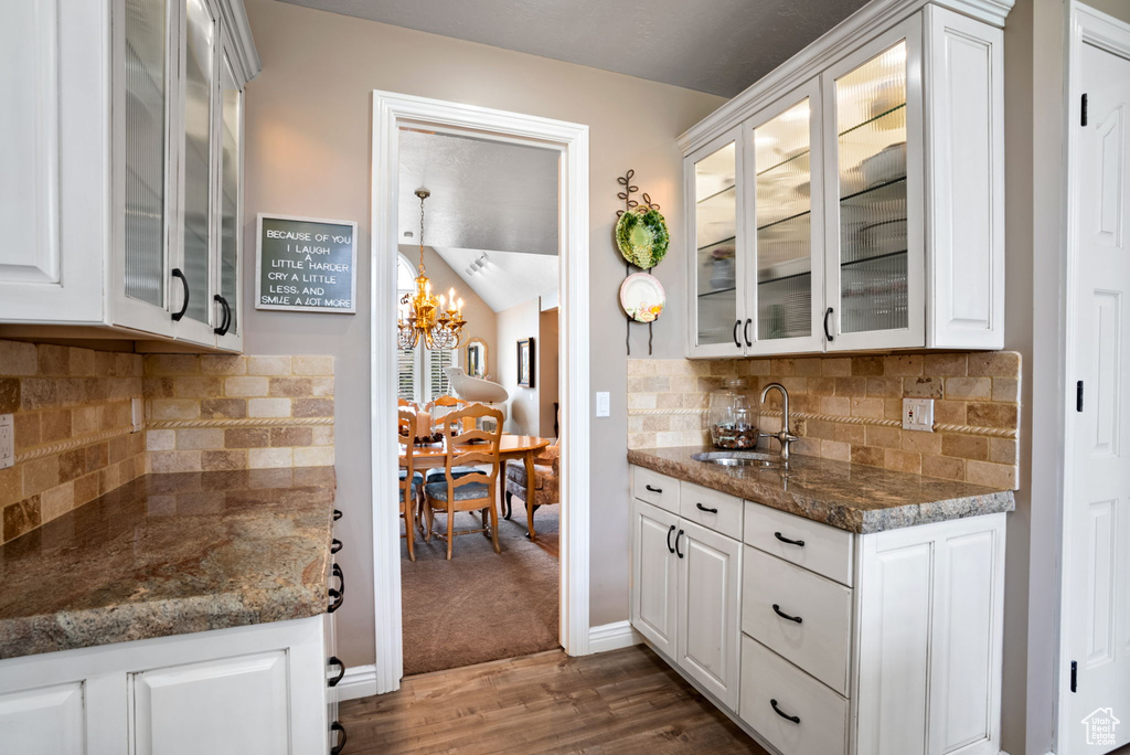 Kitchen featuring white cabinets, sink, backsplash, and dark hardwood / wood-style floors