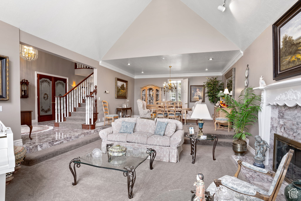 Carpeted living room with a high ceiling, a chandelier, crown molding, and a premium fireplace