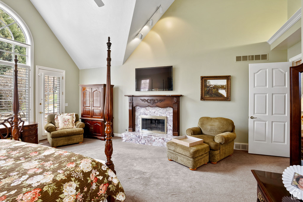 Bedroom featuring light colored carpet, high vaulted ceiling, ceiling fan, access to exterior, and track lighting