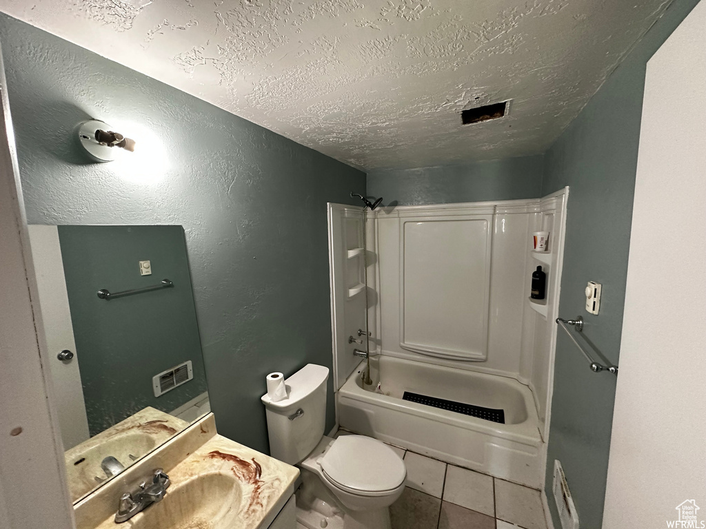 Full bathroom with a textured ceiling, shower / tub combination, toilet, tile floors, and vanity