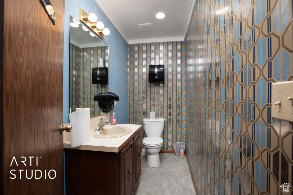 Bathroom featuring tile flooring, oversized vanity, crown molding, and toilet