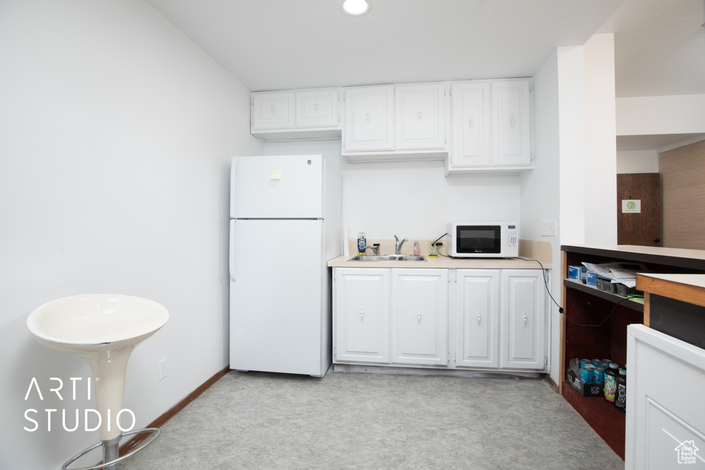 Kitchen featuring white cabinetry, white appliances, and sink