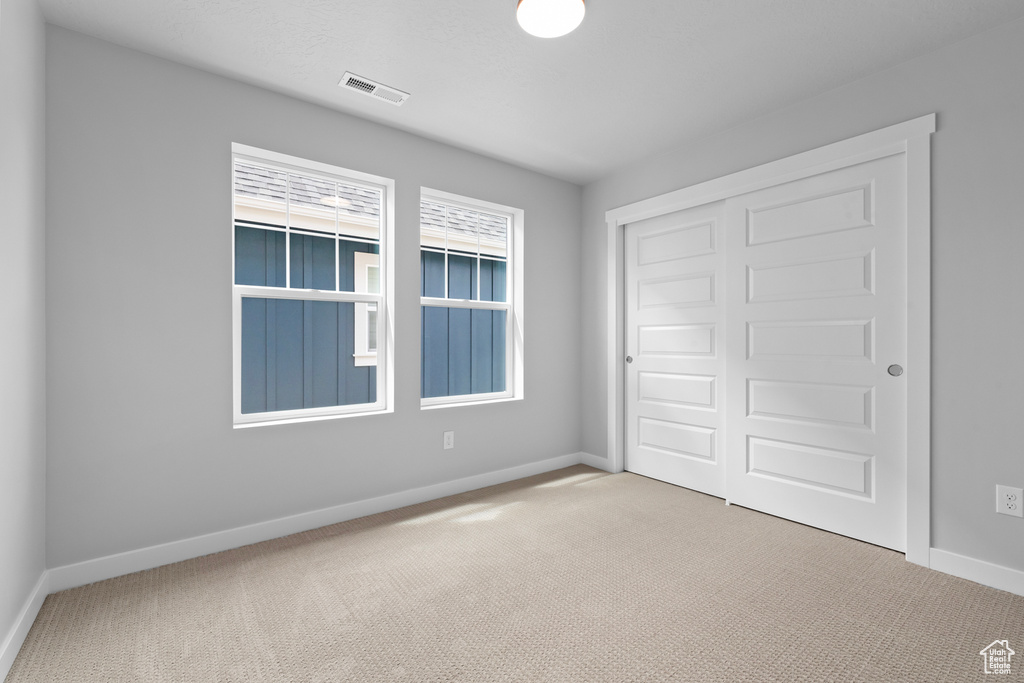 Unfurnished bedroom with carpet flooring and a closet