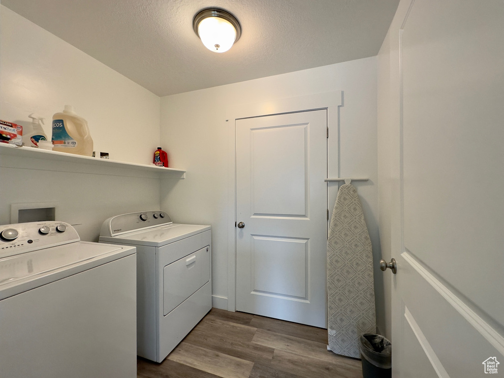 Washroom featuring washing machine and clothes dryer and hardwood / wood-style floors