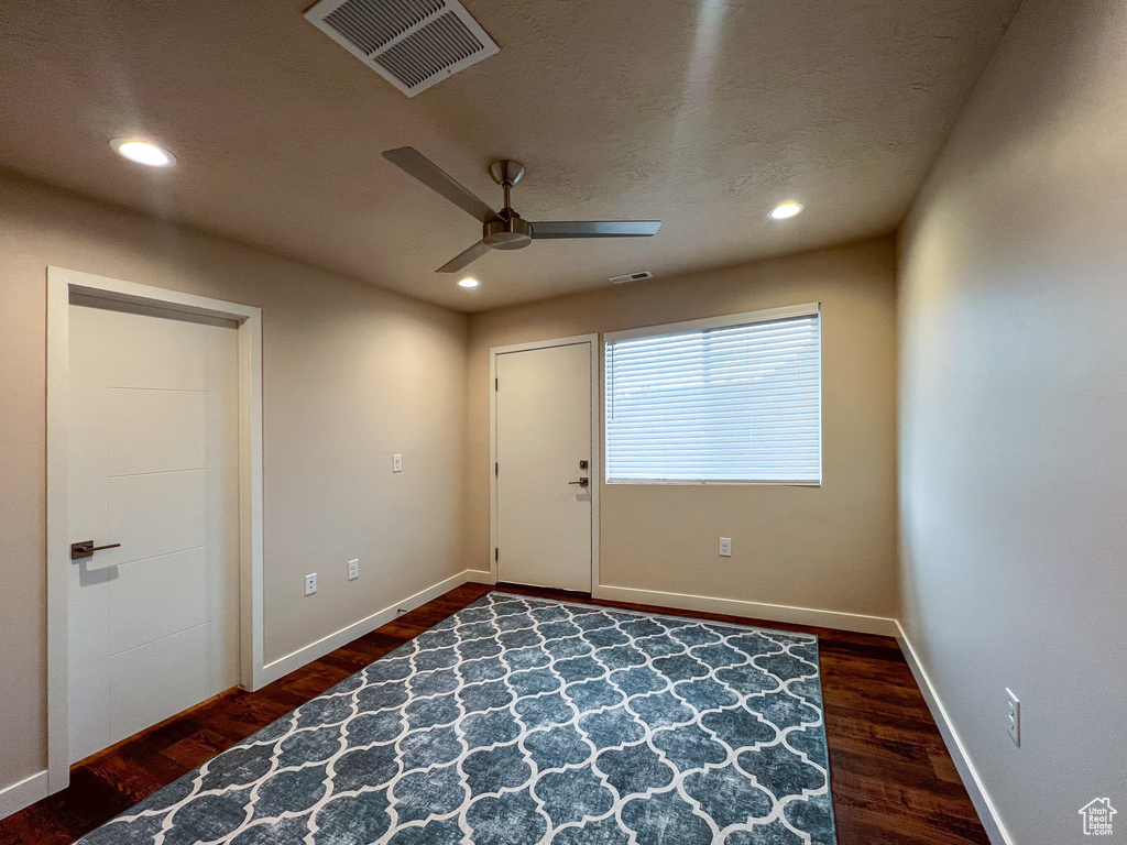 Empty room with dark hardwood / wood-style flooring and ceiling fan