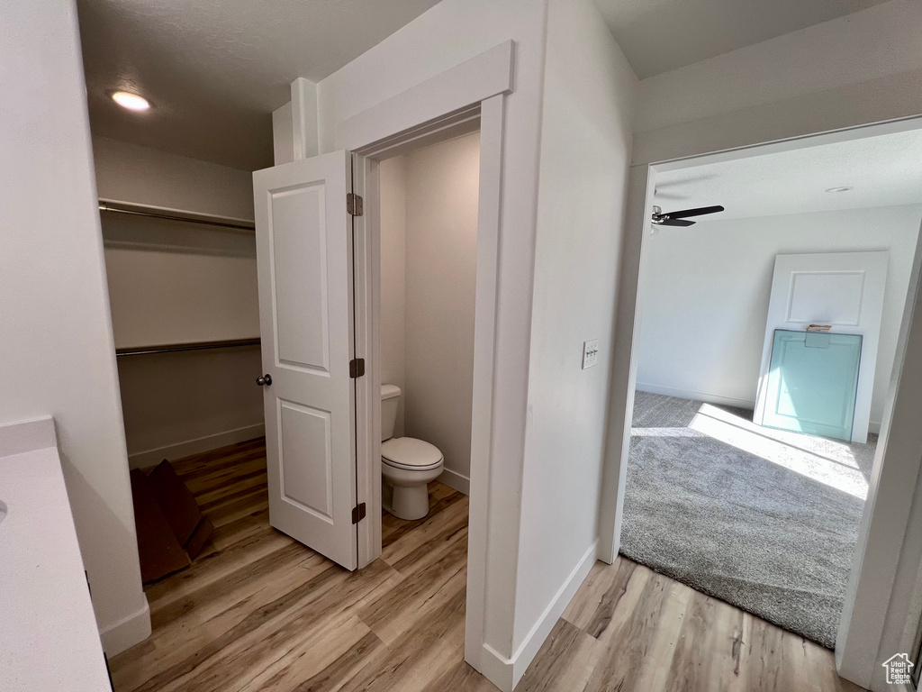 Interior space with toilet, ceiling fan, and hardwood / wood-style floors