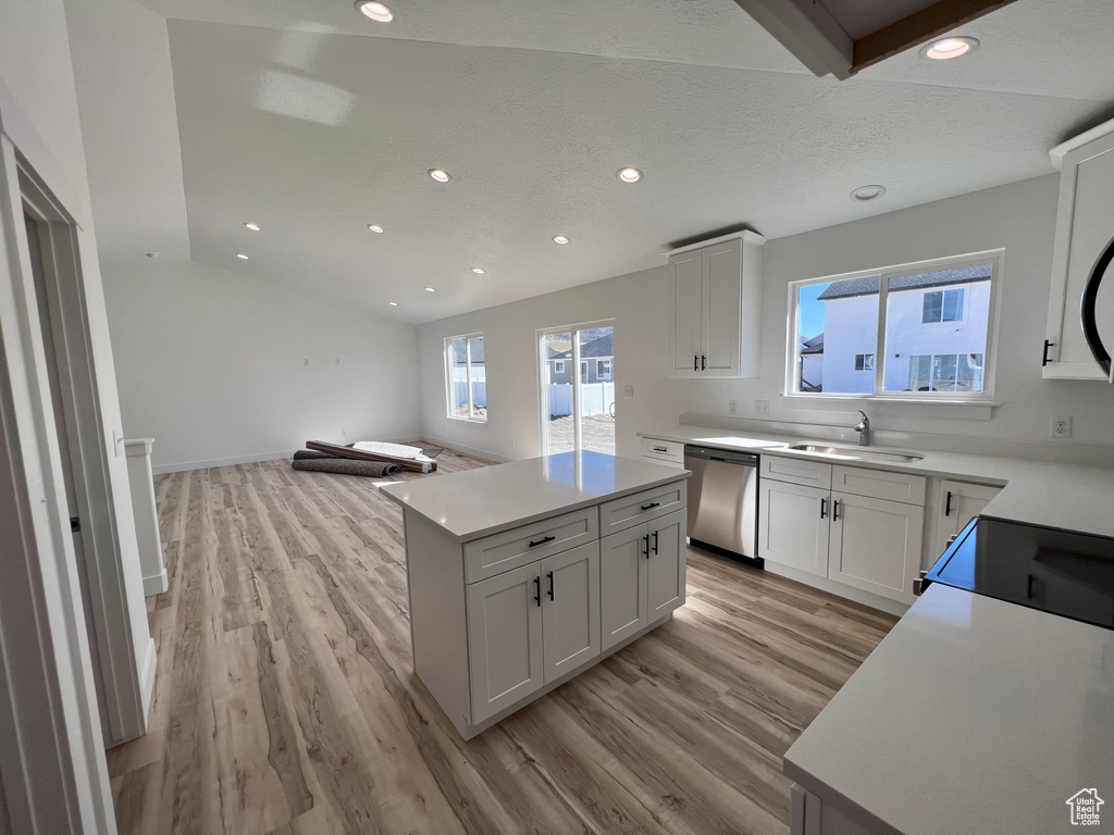 Kitchen featuring sink, light hardwood / wood-style flooring, white cabinets, and stainless steel dishwasher