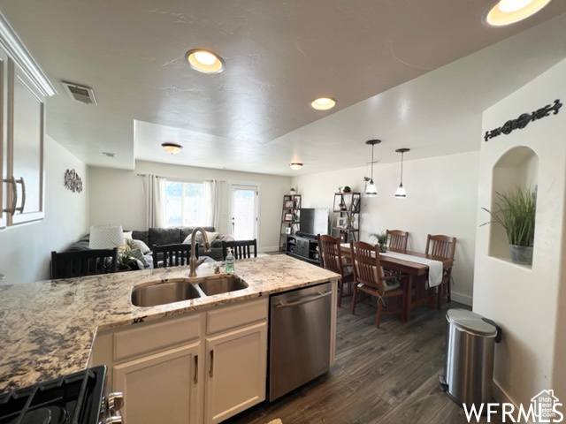 Kitchen with hanging light fixtures, dishwasher, stove, dark wood-type flooring, and sink